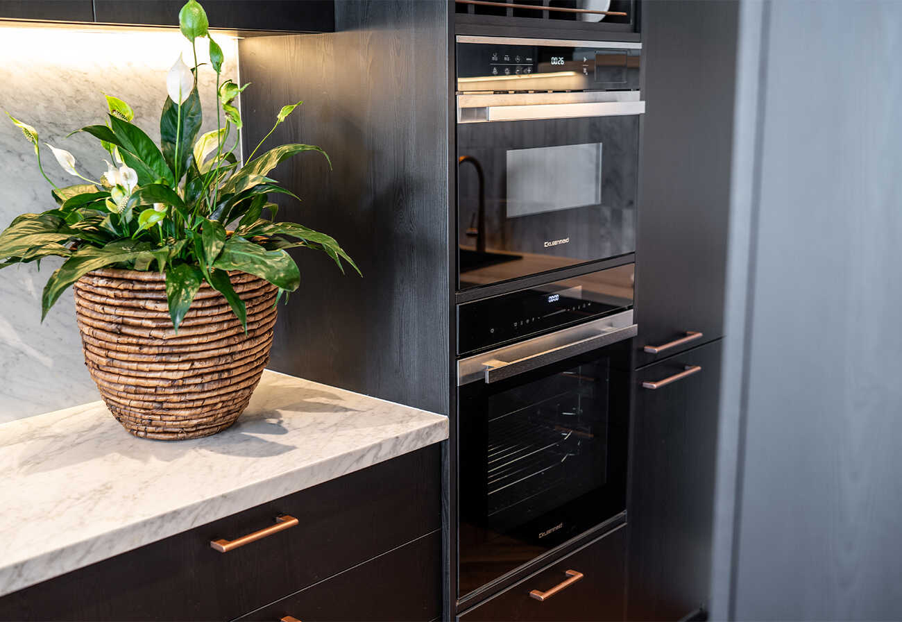 Kleenmaid wall oven and steam oven installed in black kitchen cabinetry.