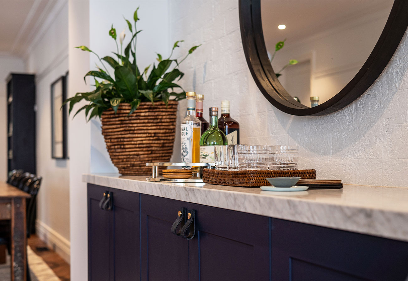 Dining room sideboard with navy cupboards and marble benchtop.