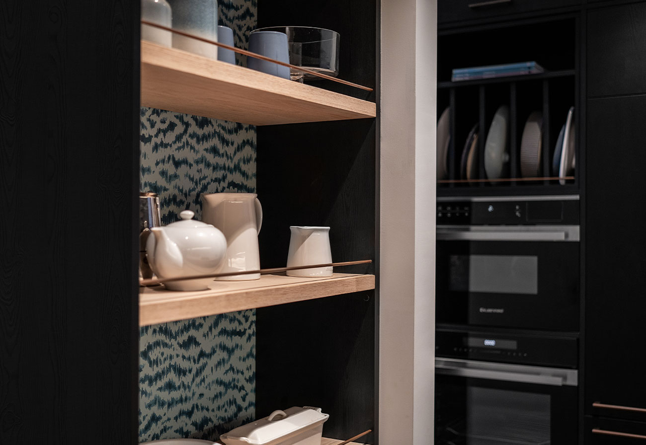 Blue wallpaper behind kitchen shelves.