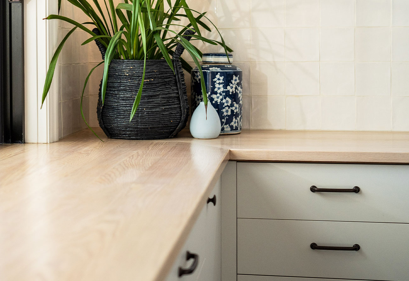 American oak laundry bench with a pot plant on top of it.