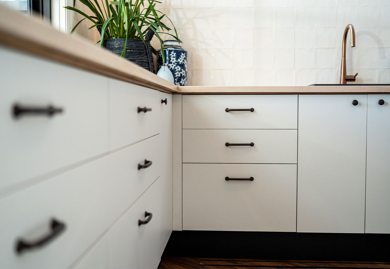 Modern Farmhouse laundry featuring white cabinets and a brushed copper tap.