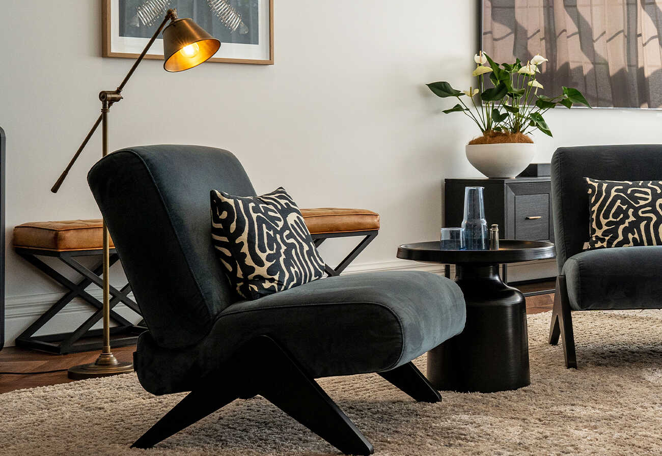 Living room with navy accent chair and brass floor lamp.