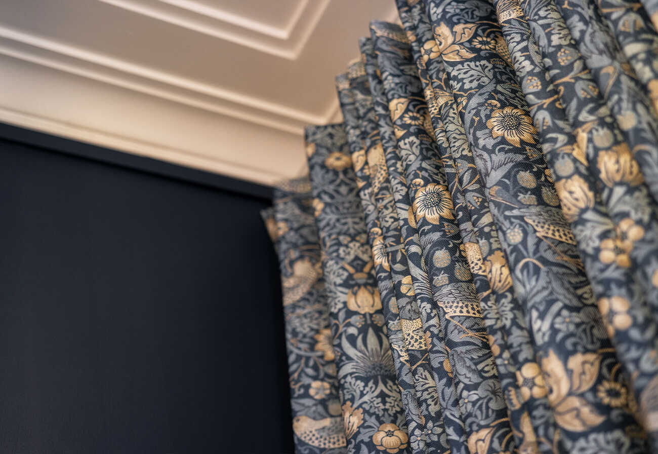 Blue patterned curtains against a blue wall.