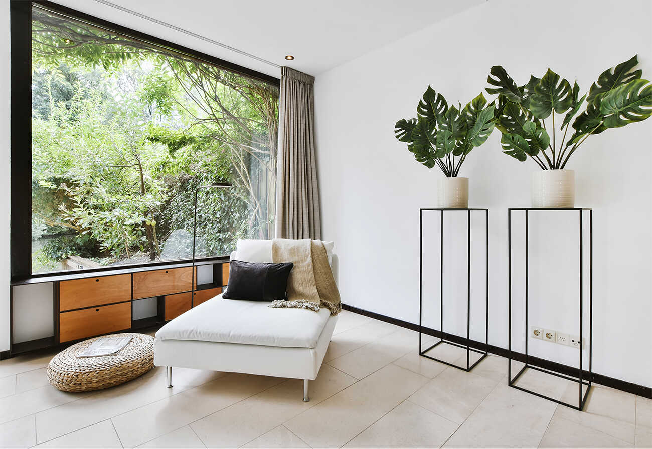 Chaise lounge next to floor-to-ceiling window.