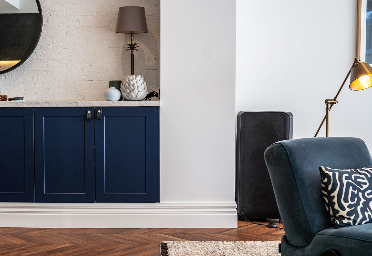 Living and dining zone with navy armchair and buffet.