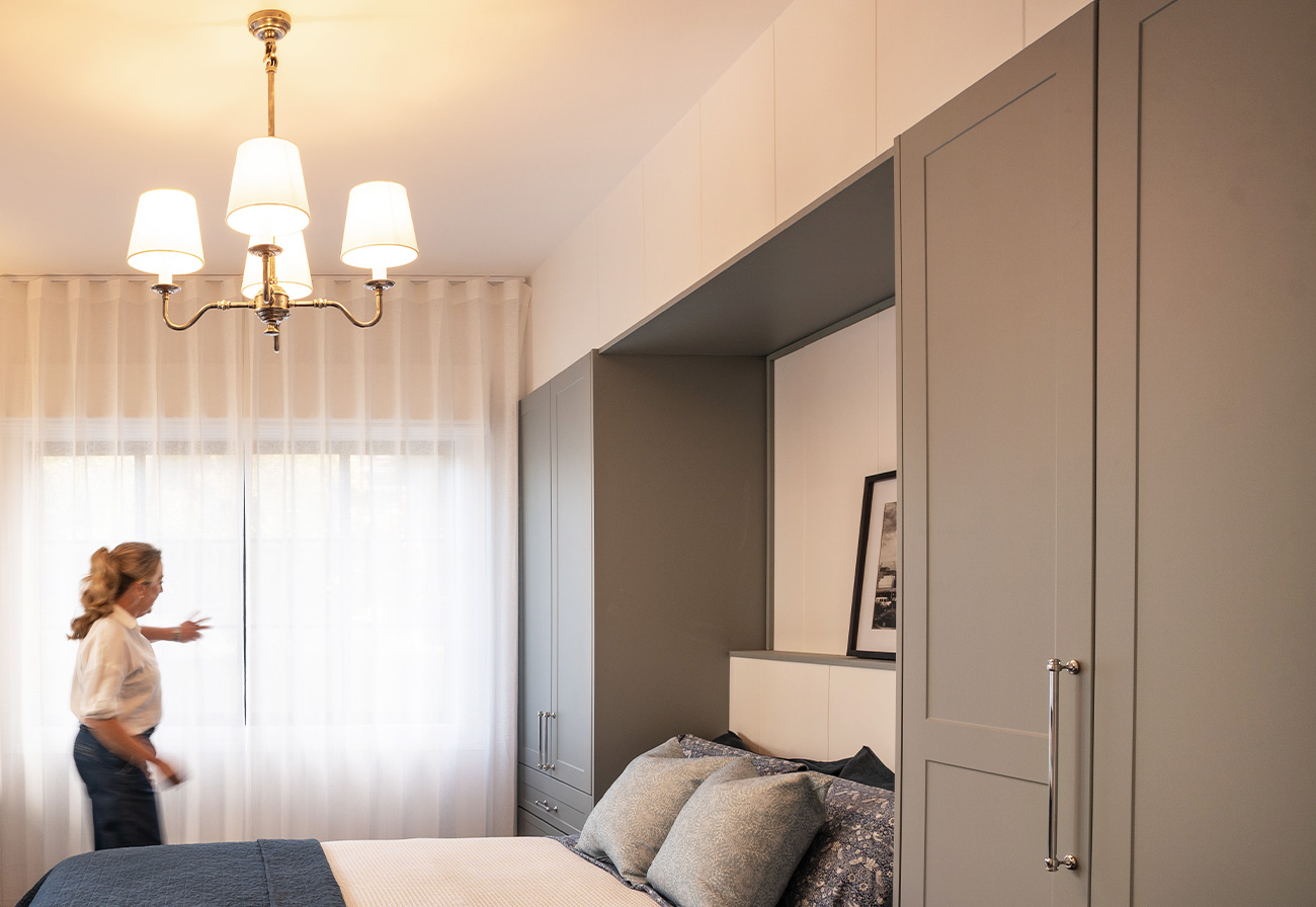 Guest bedroom with fold-down bed and chandelier overhead.