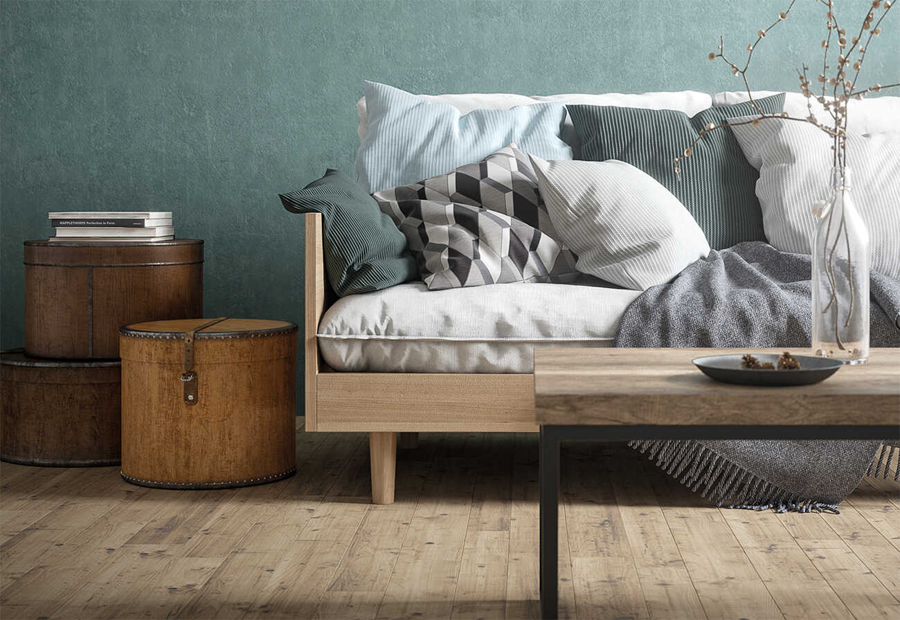 Sofa with wooden frame against a sage green wall.