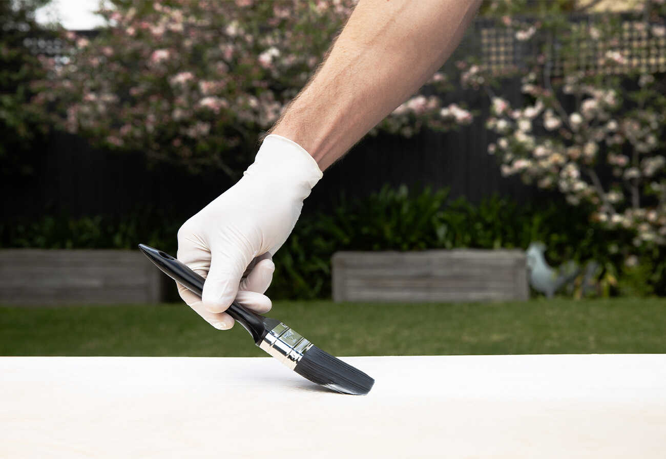 Person painting while wearing Vileda Ansell white latex gloves.