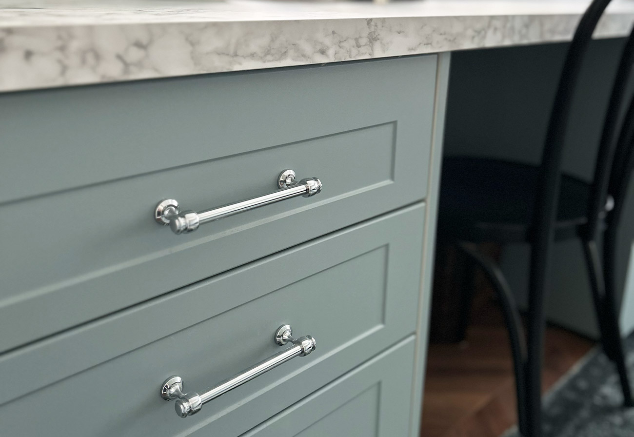 Zanda Mayfair silver handles on sage desk cabinetry.