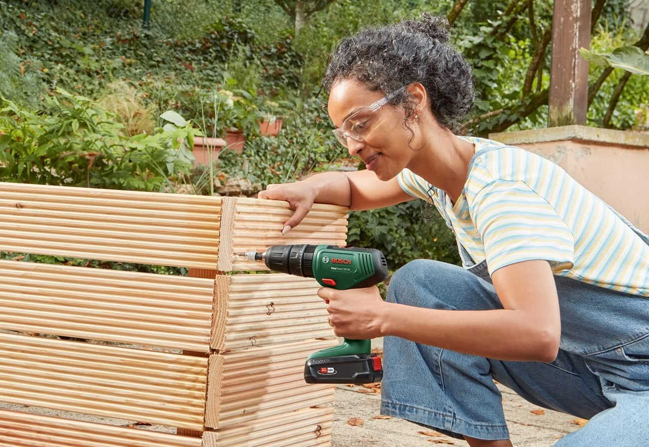 Woman using Bosch power drill outside.