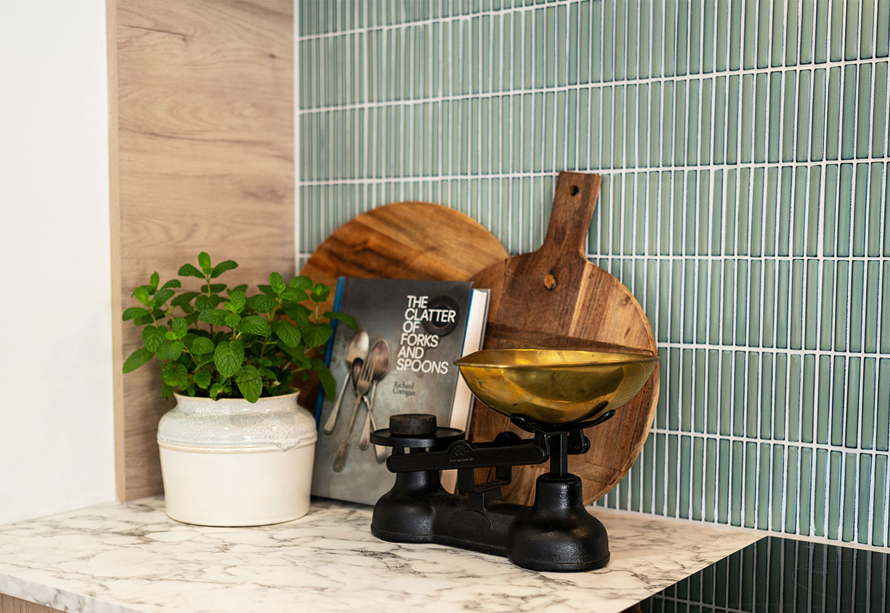 Kitchen splashback tiled with sage green fire finger tiles.