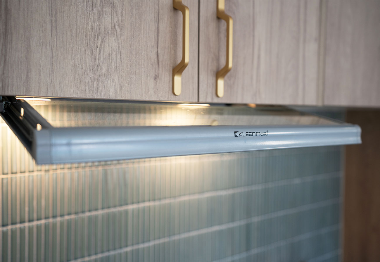 Concealed rangehood under a maplenut cabinet.