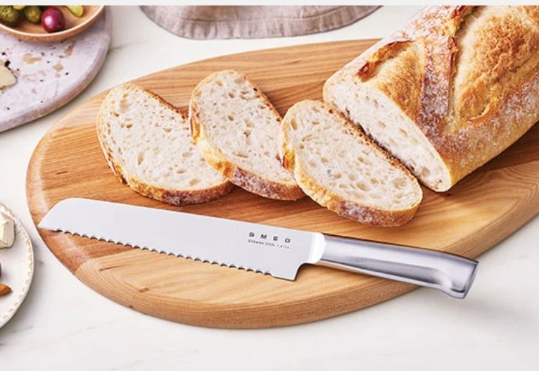 Sliced bread on a board with a SMEG knife.