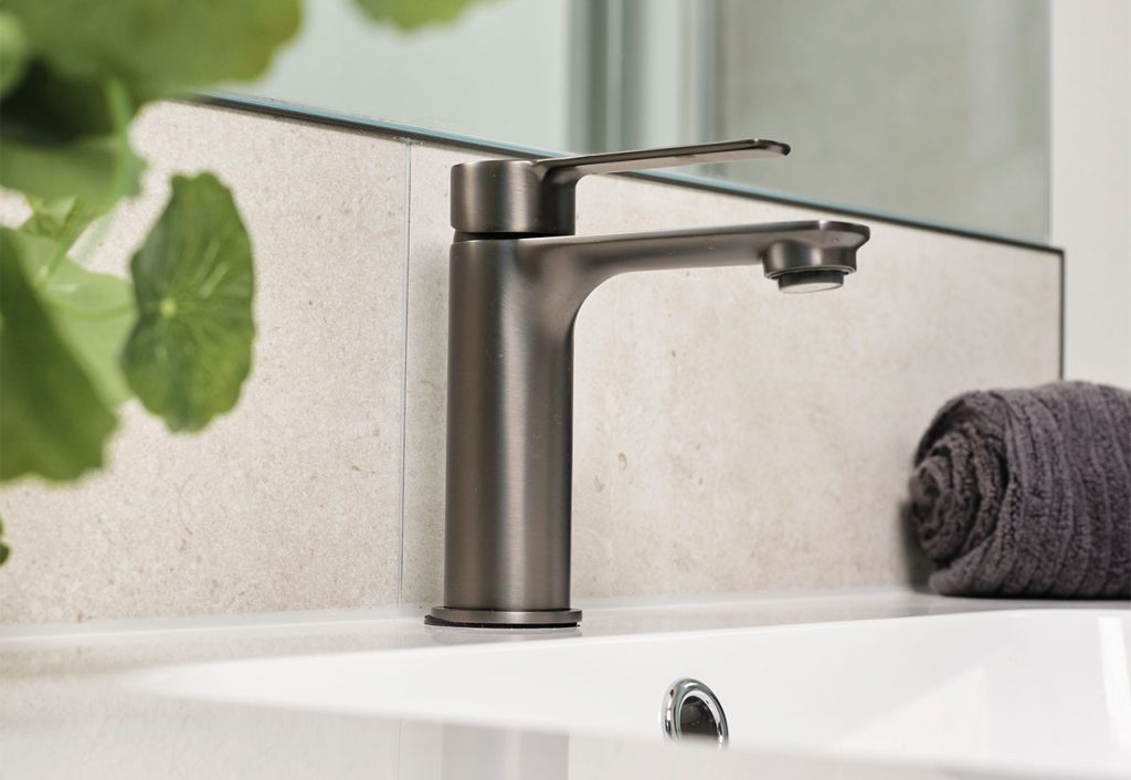 Gunmetal mixer tap against marble-look tiles.