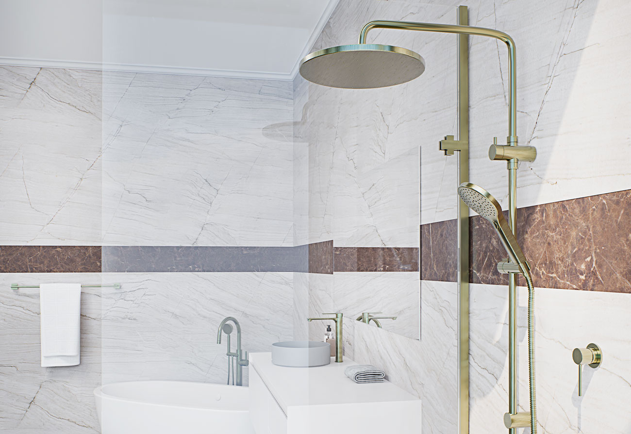 Brushed brass BubbleJet shower head and rail in a white bathroom.