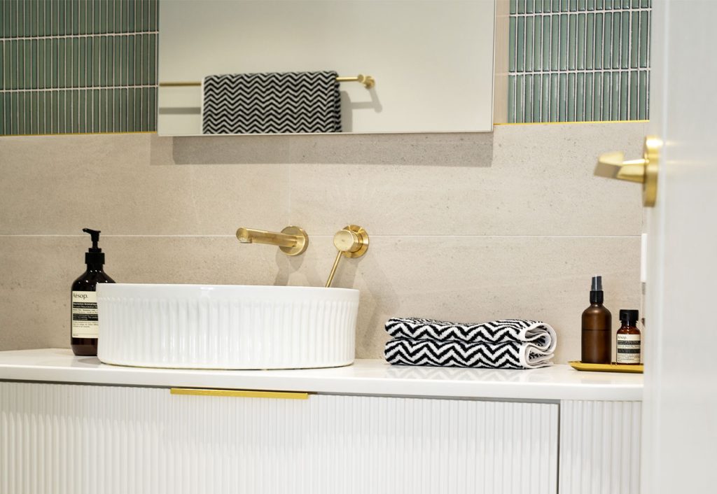 Modern bathroom featuring brushed brass metal taps and accessories.