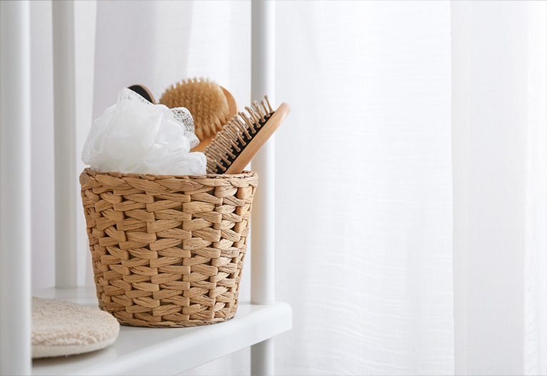 Woven basket on a shelf in a white bathroom.