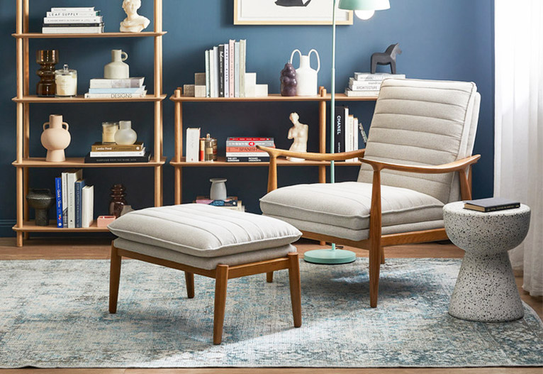 Stone-coloured upholstered mid-century chair with matching ottoman.