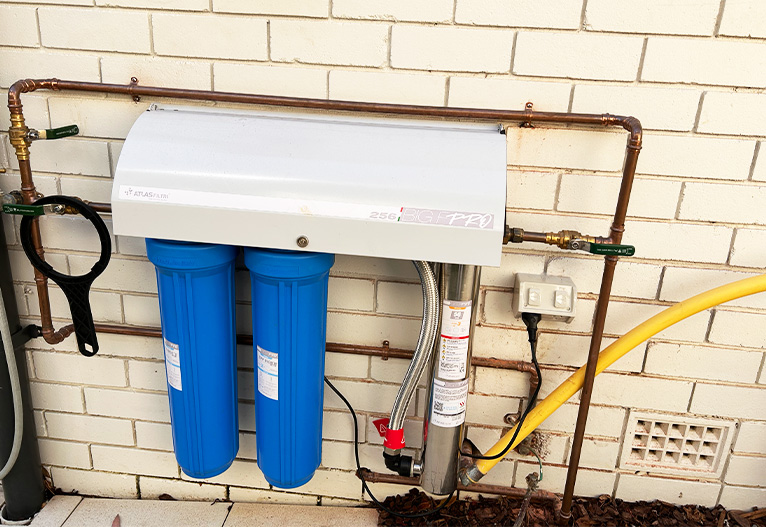 Atlas Filtri Big F 256 Water Filtration System installed on the side of a house.