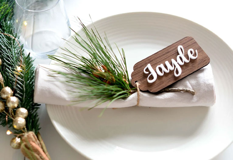 Personalised wooden place card on a table setting.