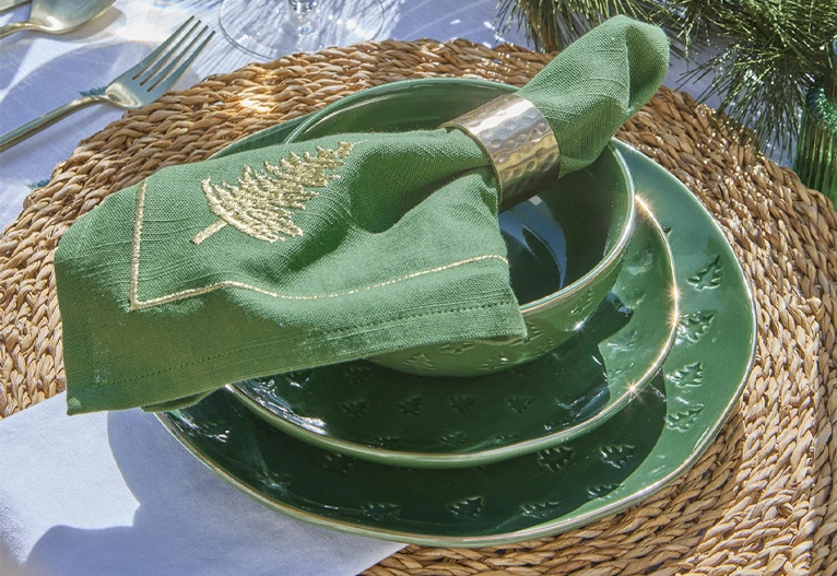 Layered green Christmas dinnerware with gold rims.