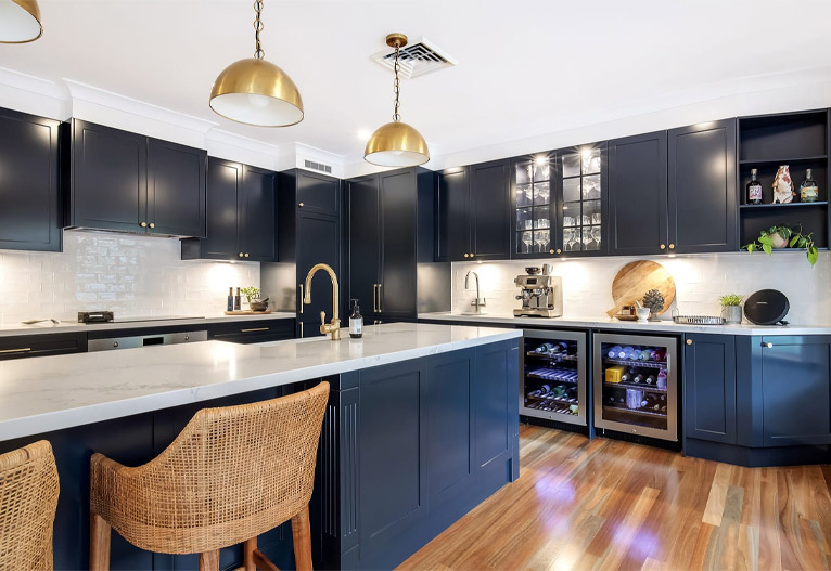 Navy blue kitchen with built-in wine fridges.