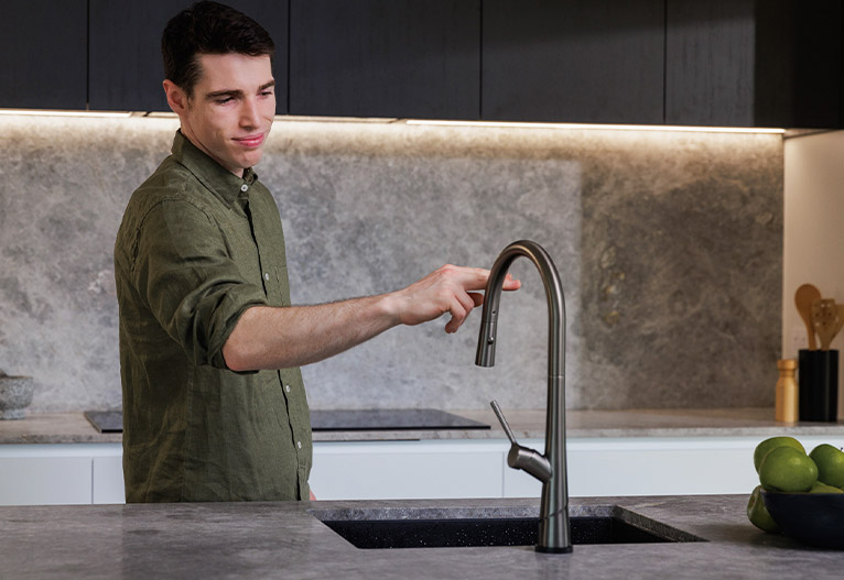 Man touches the Lustro KONTACT sink mixer.