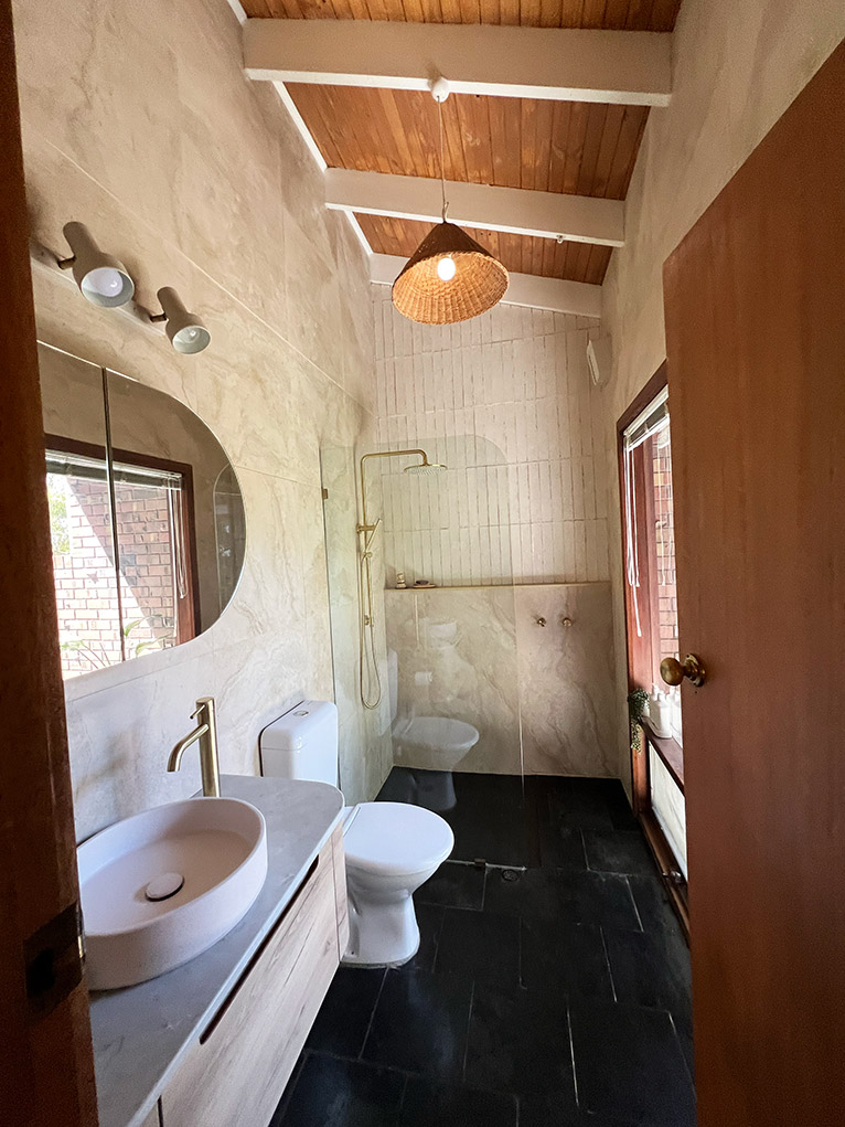 Renovated ensuite with back slate floors and timber roof.