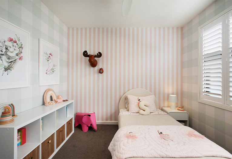 Child's bedroom with contrasting wallpaper prints.