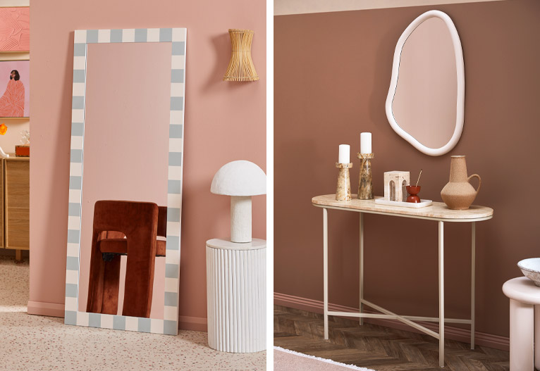 Vertical mirror leanign against a wall and a wall-hung organic shaped mirror.