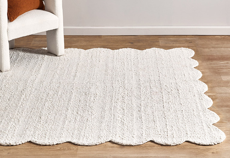 White boucle floor rug with scalloped edges.