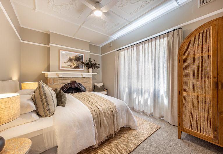 Renovated bedroom with sheer curtains.