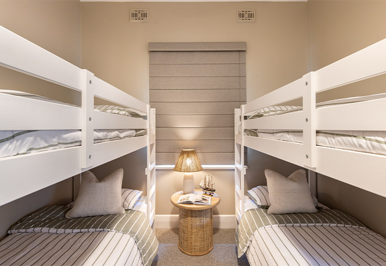 Kids' bunk room with grey window furnishings.