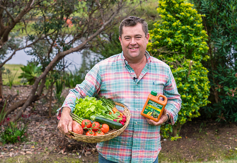 Jason Hodges holding a bottle of Charlie Carp fertiliser.