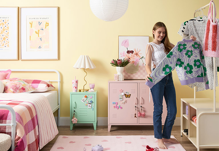 Girl looking at clothes in her bedroom.