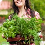 Woman carrying freshly picked herbs.