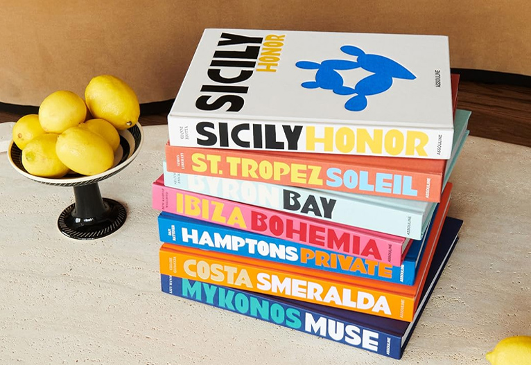 Stack of Assouline travel books next to a tray of lemons.