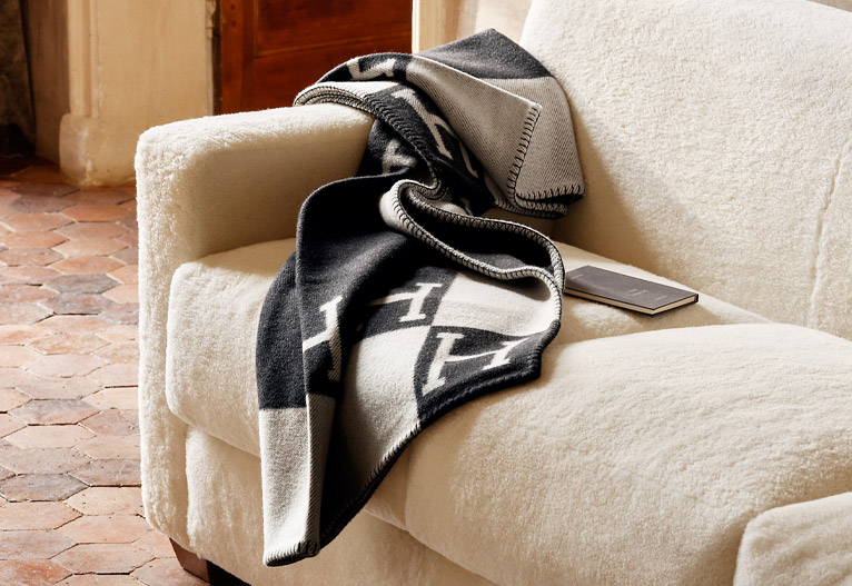 Hermes black and white Avalon Throw Blanket on a white sofa.