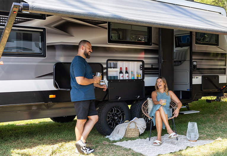Couple sitting outside the Crusader Caravans Designer Series.