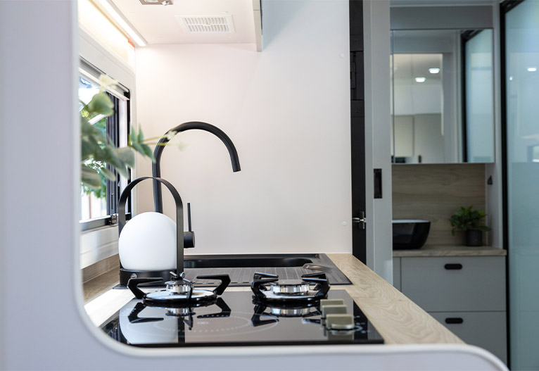 Modern caravan kitchen with gooseneck tap.