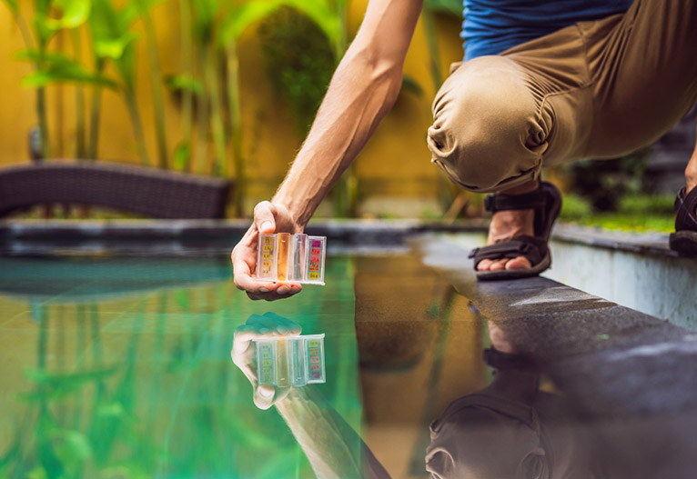 Man checking the water chemistry of his pool.
