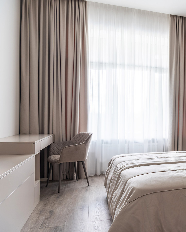 Bedroom with layered sheers and curtains.