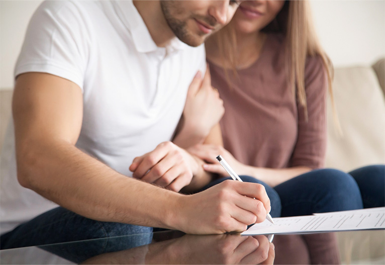 Couple signing a form.