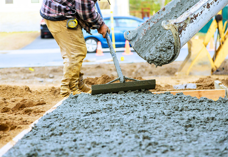 Builder preparing freshly poured concrete onto a slab.