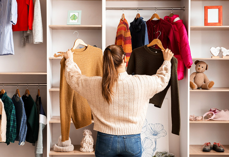Woman choosing an item of clothing from her wardrobe.