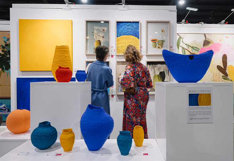 Women choosing art at the Brisbane Affordable Art Fair.