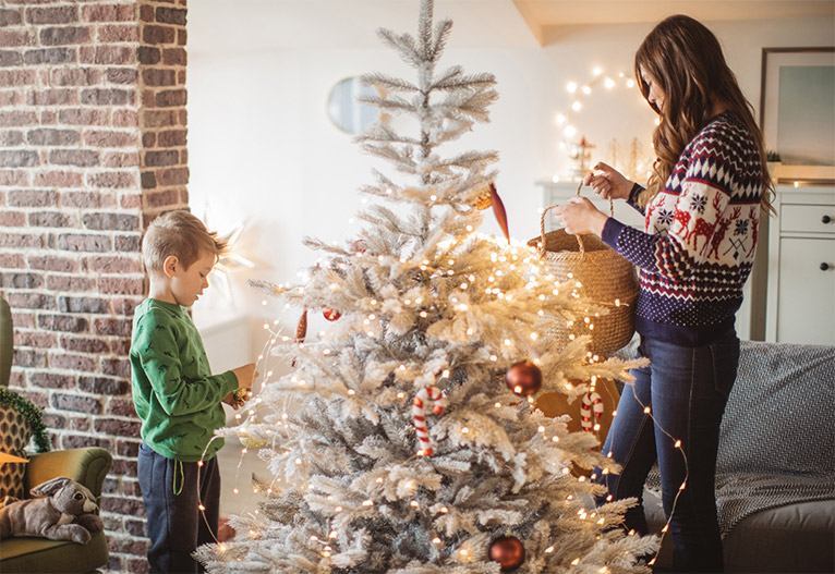 Mother and child decorating a Christmas tree.