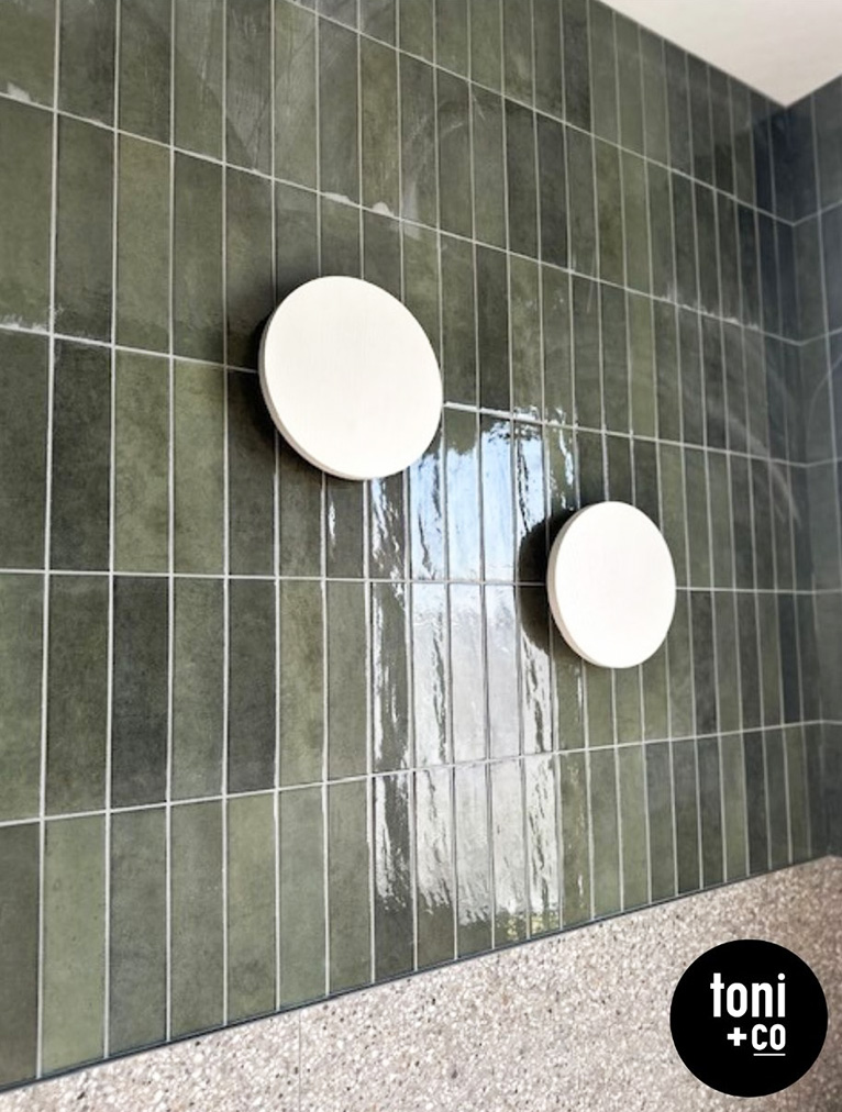 Green vertical tiles on a bathroom wall.