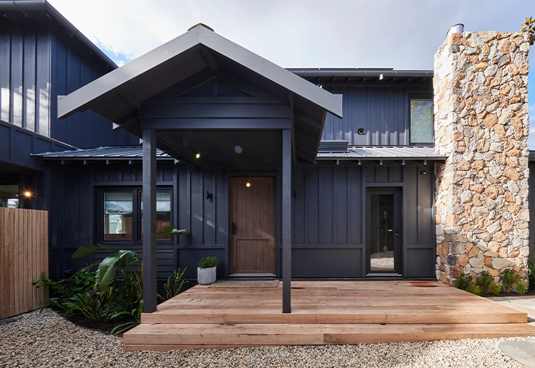 Black, modern weatherboard house facade.