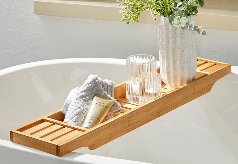 Sanctuary bath caddy in natural bamboo on a white tub.